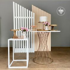 two white chairs sitting next to each other in front of a table with flowers on it