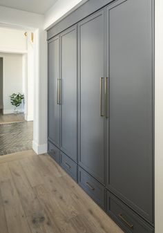 an empty room with large gray cabinets and wood floors