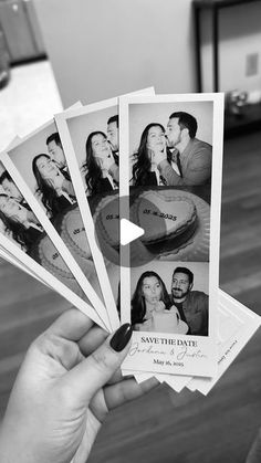 black and white photograph of wedding photos being held in front of the camera by someone