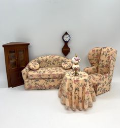 a living room with two couches and a table in front of a clock on the wall