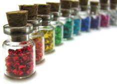 a row of small glass bottles filled with different colored confetti