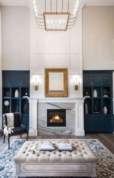 an elegant living room with blue and white furniture, a fireplace, and chandelier