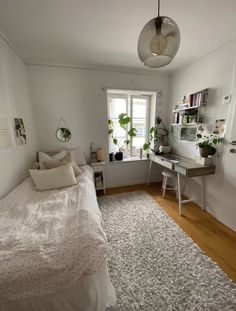 a bedroom with a bed, desk, and window in it's center area