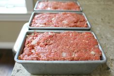 three pans filled with meat sitting on top of a counter