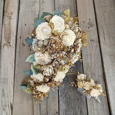 the bridal bouquet is made up of flowers and greenery on a wooden surface