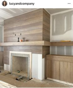 an unfinished room with wood paneling and a fireplace