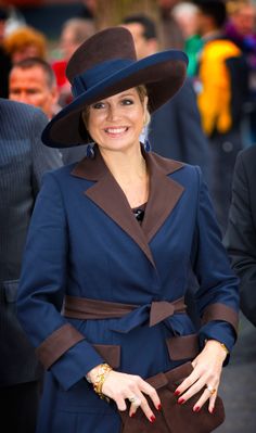 a woman wearing a blue coat and brown hat