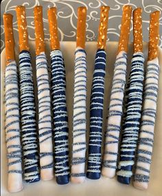 several blue and white candles are lined up in a row on a plate with gold glitters