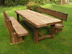 a wooden table and bench in the grass