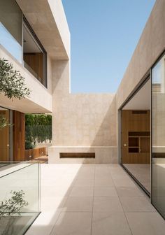 an empty courtyard with glass doors and trees