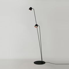 a black floor lamp with two lights on each side and one light on the other