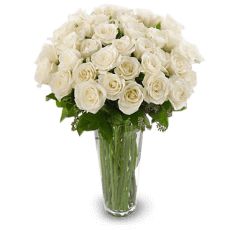 a vase filled with white roses on top of a table