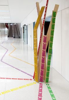 the hallway is decorated with colorful strips of paint and wooden sticks that are sticking out of them