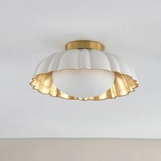 a white and gold ceiling light hanging from the ceiling in a living room or bedroom