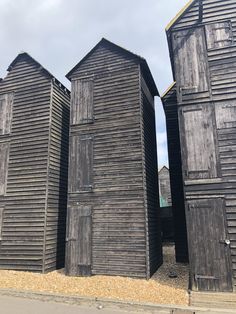 three black wooden buildings sitting next to each other