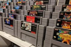 several rows of video games are on display in a game store, all lined up against the wall