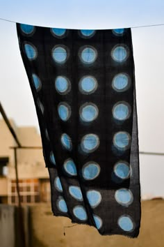 a black and blue scarf hanging from a clothes line