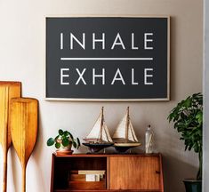 there is a sign that says inhale and exhale on the wall above it