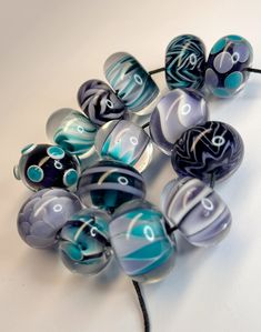 a bunch of glass beads sitting on top of a white table next to each other