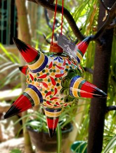 an ornament hanging from a tree in the shape of a bird with horns