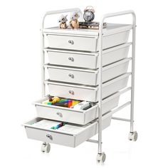 a white cart with five drawers and two stuffed animals on it's top shelf