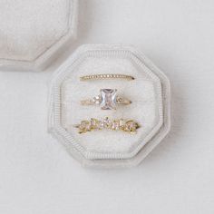 two engagement rings sitting on top of a white box