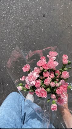 a bouquet of pink flowers sitting on top of a person's lap in the rain