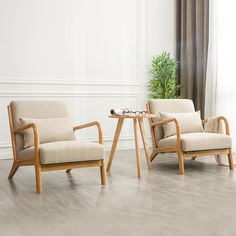 two chairs sitting next to each other on a hard wood floor in front of a window