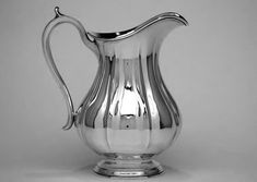 a silver pitcher sitting on top of a table