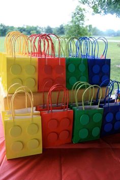 many bags are stacked on top of each other in different colors and sizes, with the handles made out of legos