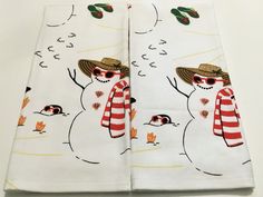 two napkins with snowmen wearing hats and scarfs