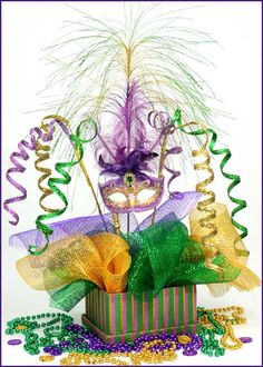 a mardi gras mask and streamers in a gift box