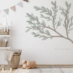 a baby's room with a tree painted on the wall