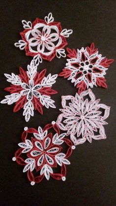 four red and white snowflakes on a black surface