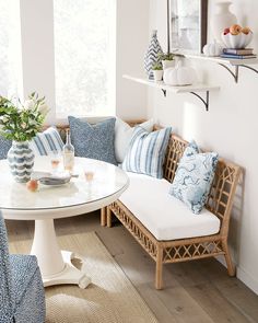 a white table with blue and white pillows on it