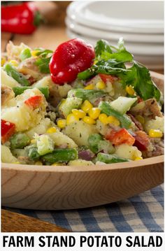 a wooden bowl filled with potato salad on top of a table