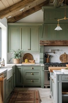 a kitchen with green cabinets and white counter tops, an oven and sink are in the center of the room