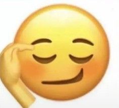 a person touching the forehead of an emoticive smiley face with their eyes closed