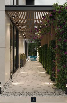 the walkway is lined with purple flowers and greenery on either side of the pool