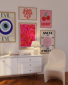 a white chair sitting next to a table in a room with pictures on the wall