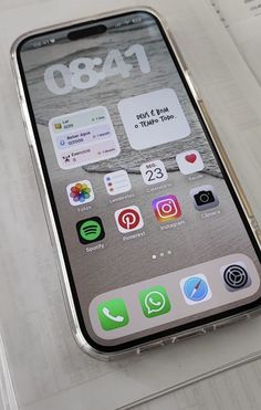 an iphone sitting on top of a table next to some papers and pen with icons