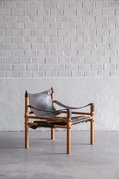 a chair sitting on top of a cement floor next to a white brick wall in an empty room