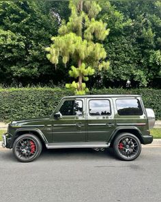 a green jeep parked in front of a tree