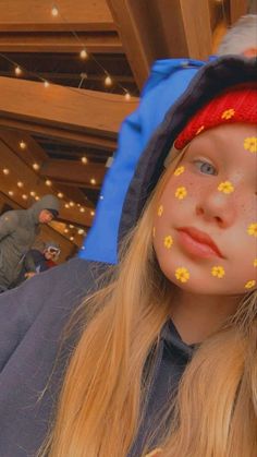 a girl with yellow flowers painted on her face