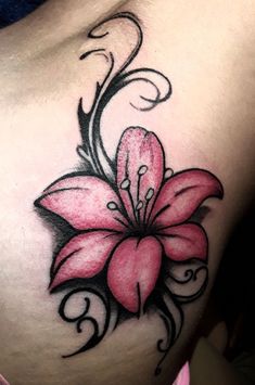 a pink flower tattoo on the side of a woman's stomach, with black and white swirls