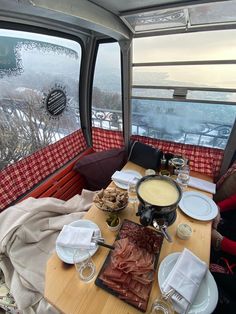 a table with plates and silverware on it in front of a window overlooking the city