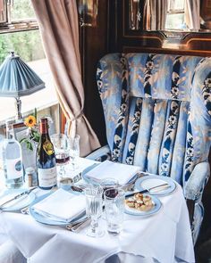 an image of a table setting with food and drinks on it in the dining car