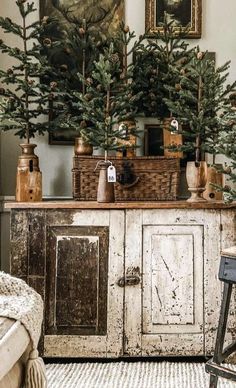 an old dresser with christmas trees on top and other decorations in the room behind it