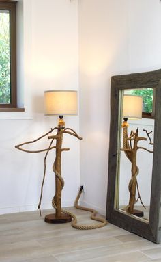 a lamp and mirror in a room with wood flooring next to eachother