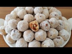 a white plate topped with donuts covered in powdered sugar